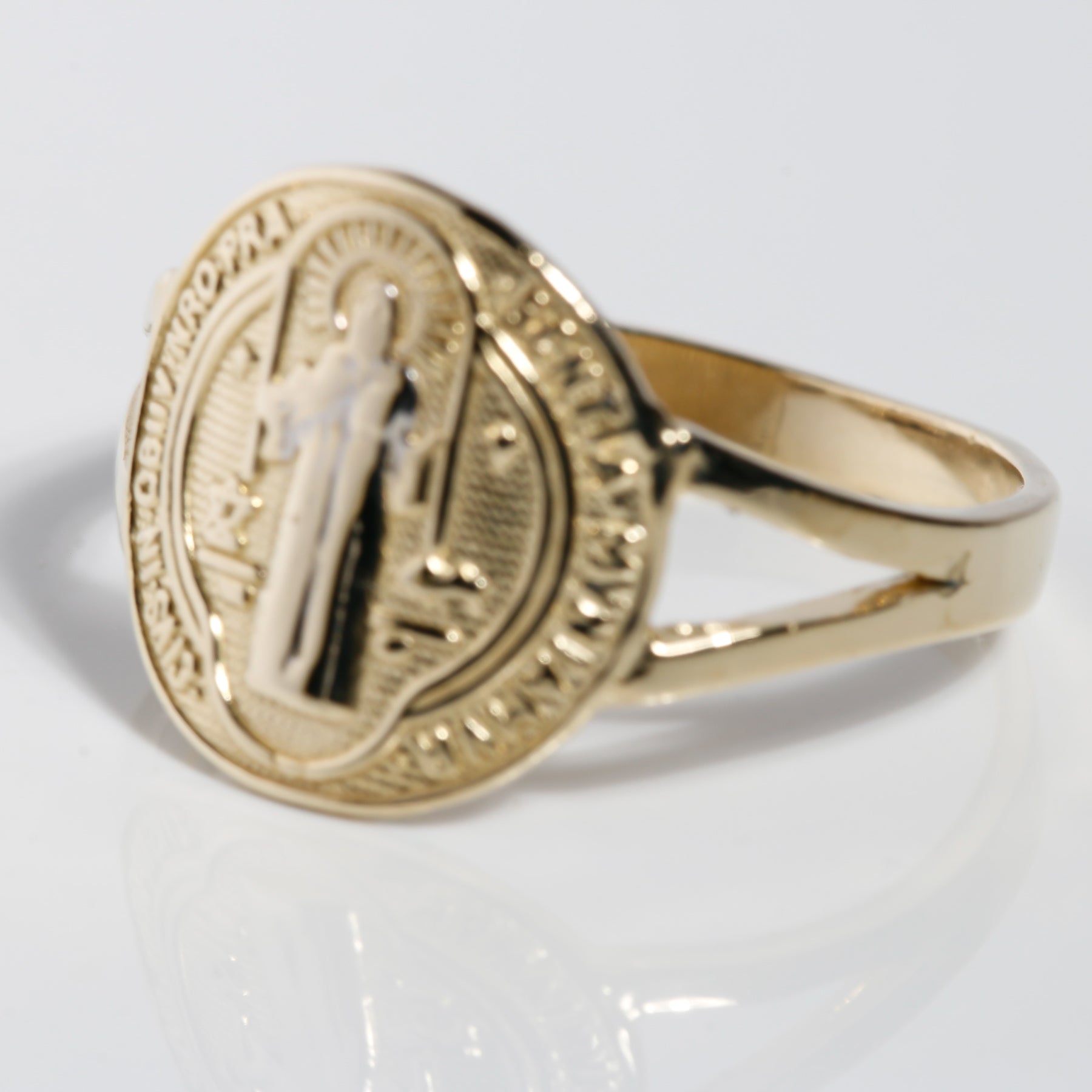 Angled view of two-tone 14K gold San Benito ring with white gold saint