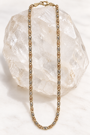     14K solid tri-color gold diamond-cut Mariner Gucci link chain, 18 inches and 11 grams, displayed on white quartz.