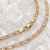     Close-up of the lobster clasp and diamond-cut yellow, white and rose gold links on a 14K solid gold Mariner chain.