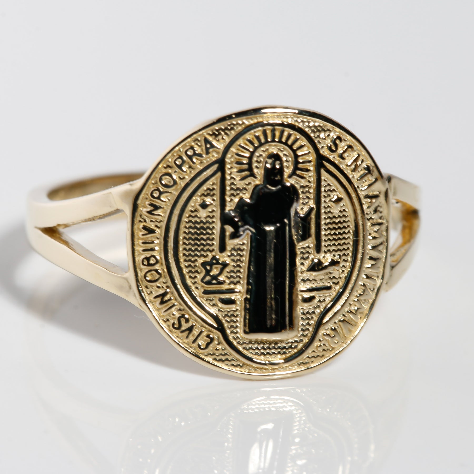 Angled view of two-tone 14K gold San Benito ring with white gold saint